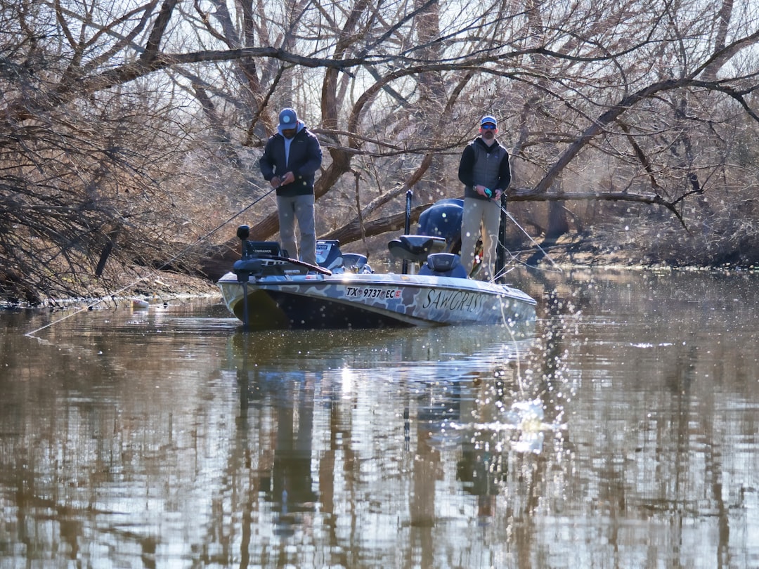 A sleek bass boat gliding across a serene lake, surrounded by lush greenery, perfect for fishing enthusiasts.