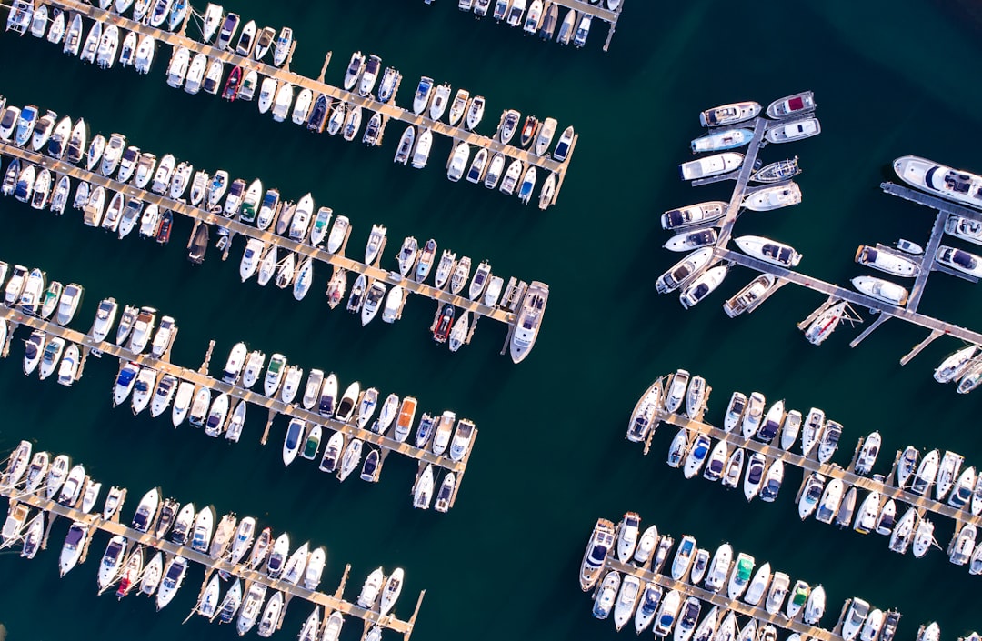 A secure boat storage facility with boats neatly parked and surrounded by a fence.