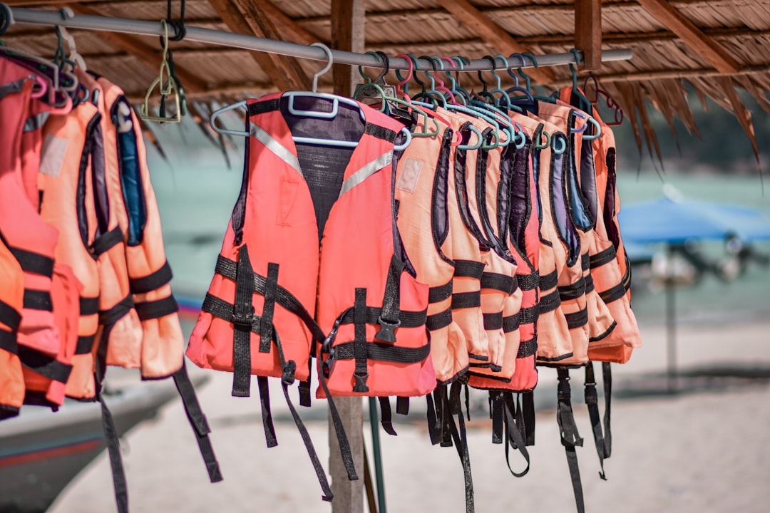 A person wearing a bright life jacket while enjoying a day on a boat in a serene lake setting.
