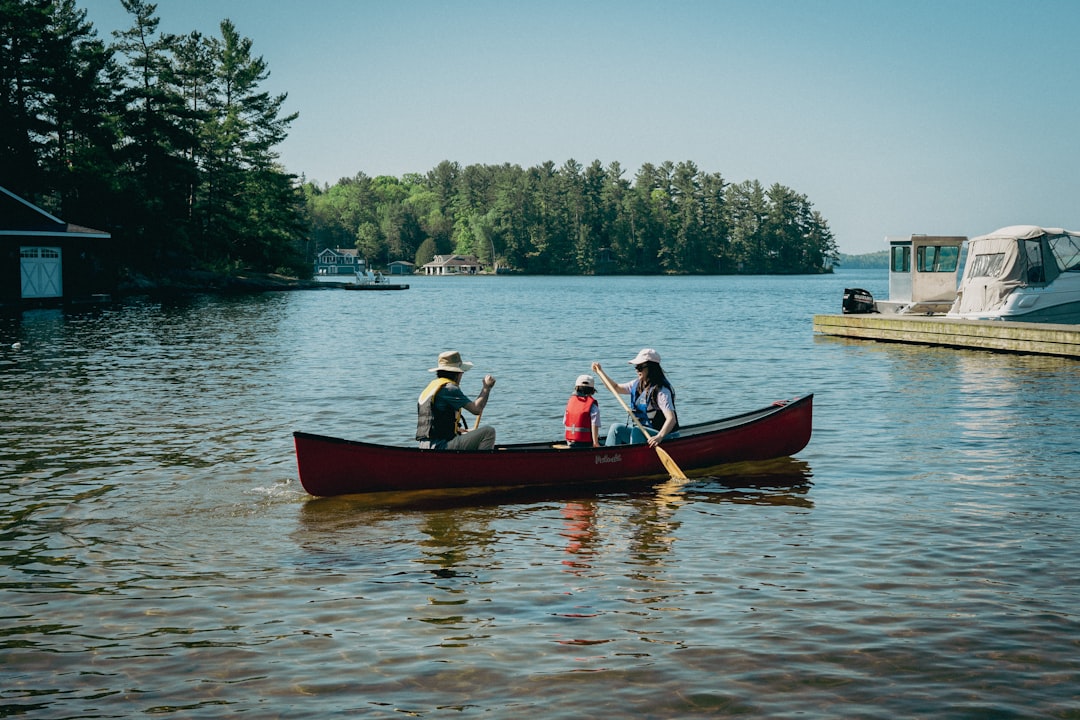 A family enjoying a day on a boat, smiling and having fun on the water with life jackets and sunny weather.