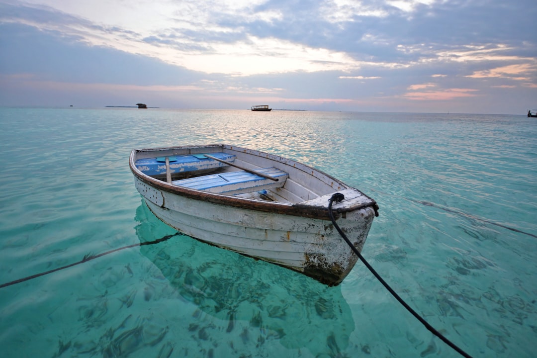 A well-maintained boat docked at a marina, with a clear blue sky and gentle waves, showcasing protective covers and equipment against sun and weather damage.