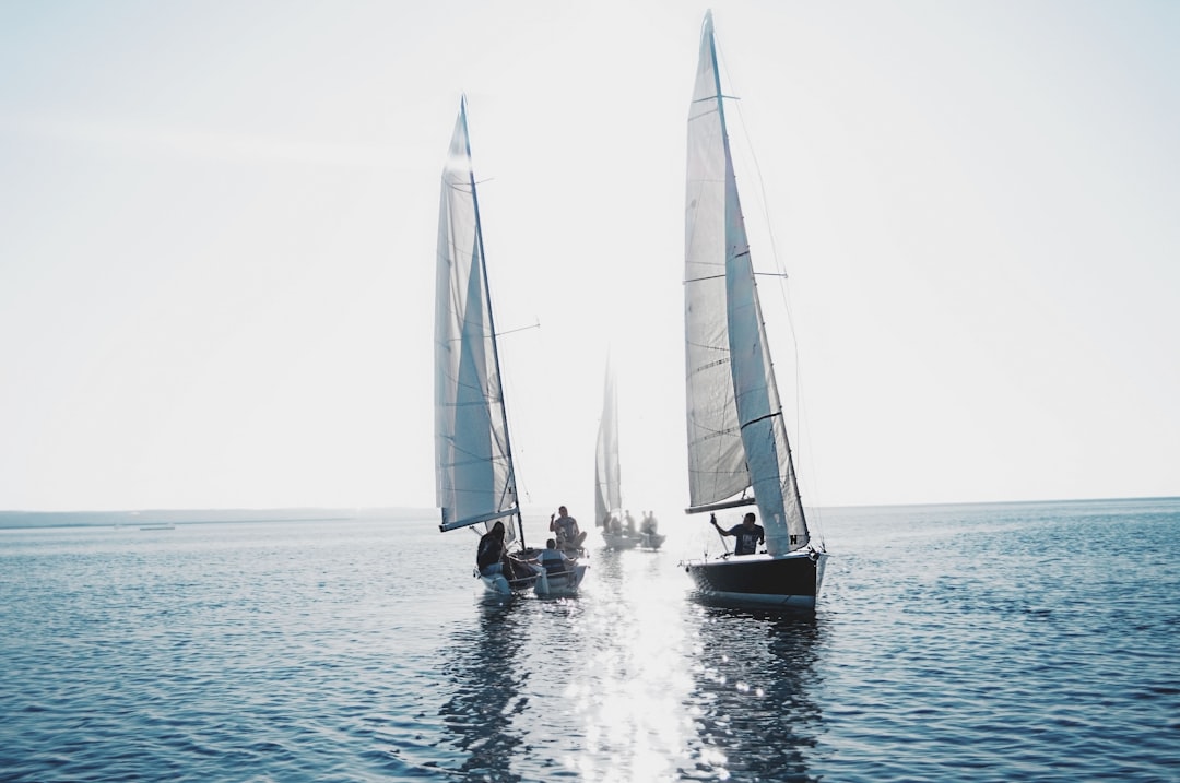 A serene view of a sailboat on calm waters with sailing gear laid out on the deck, symbolizing preparation for a sailing trip.